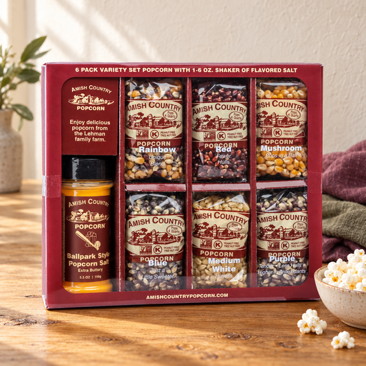 Amish Country Popcorn Six-Pack Variety Set six kernel bags with one seasoning-salt shaker beside popcorn on a wooden table