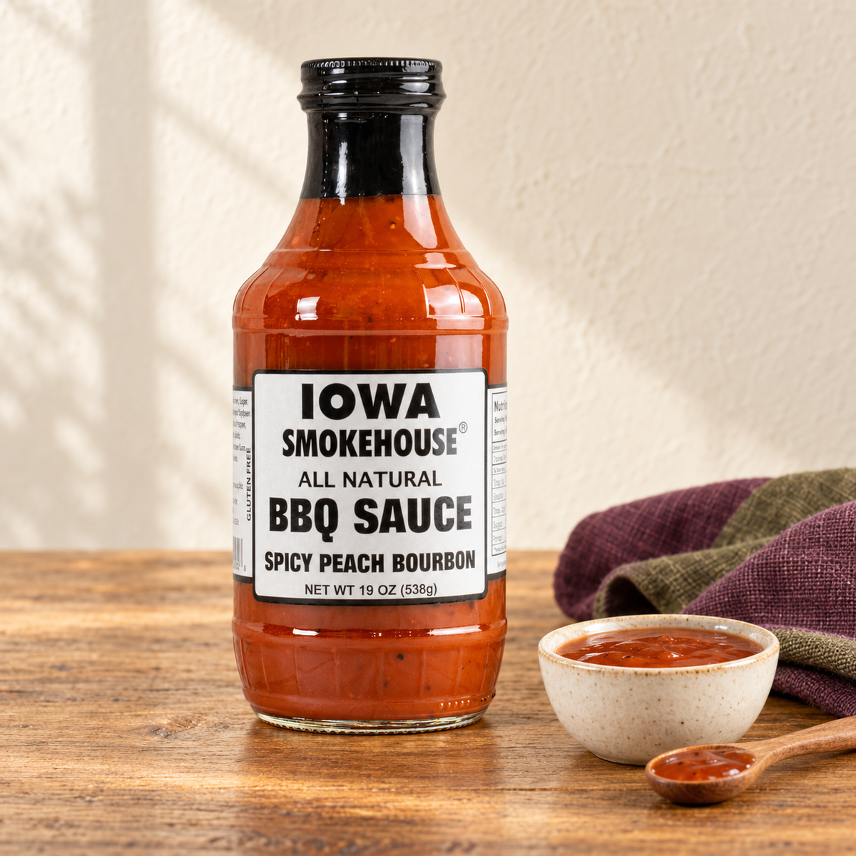 Iowa Smokehouse Spicy Peach Bourbon BBQ Sauce, 19 oz (538g) beside a small serving