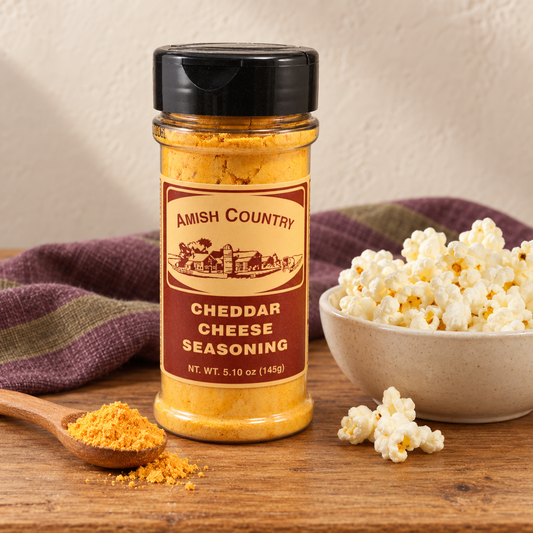 Cheddar Cheese Popcorn Seasoning 5.10 oz (145g) beside popcorn on a wooden table