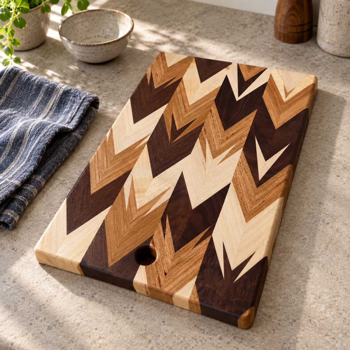 Amish-made chevron cutting and serving board in cream, honey and dark natural wood tones, styled on a kitchen counter with its surface unobscured.