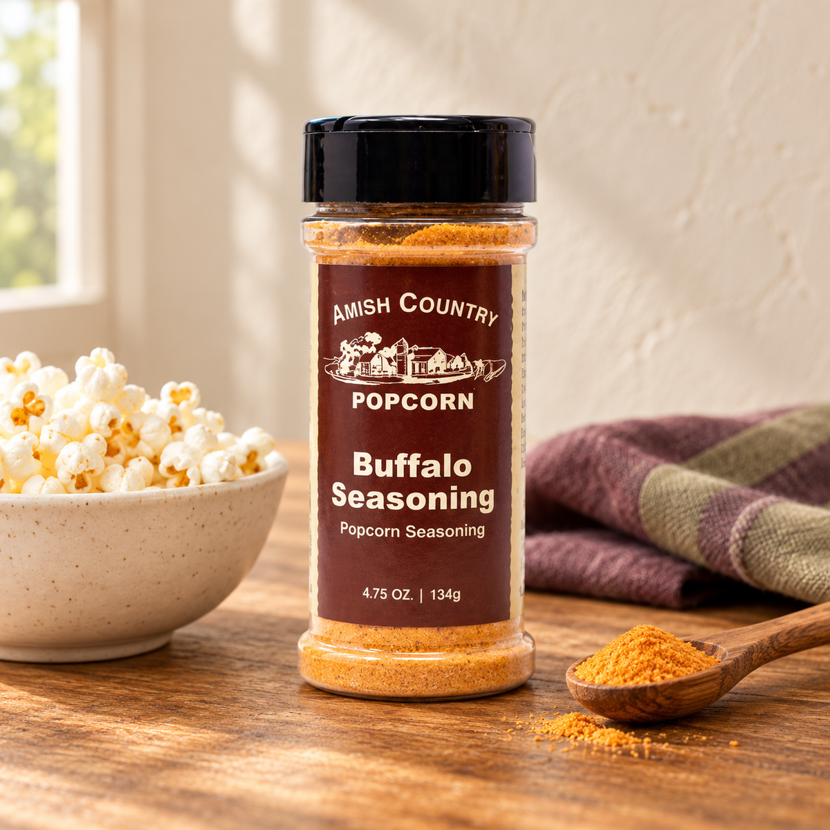 Buffalo Popcorn Seasoning 4.75 oz beside popcorn on a wooden table