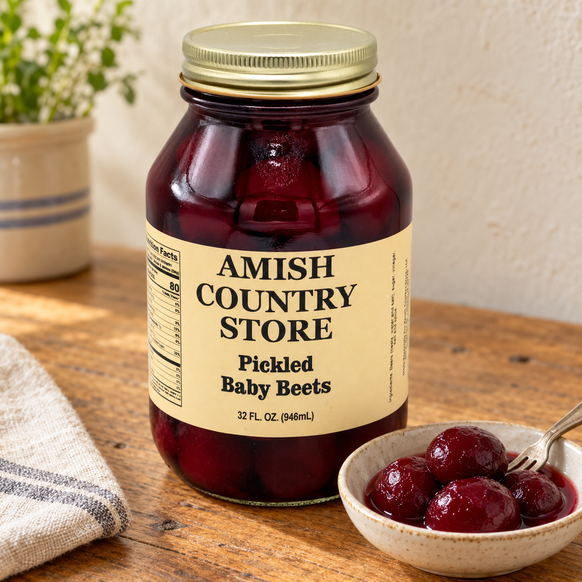 32 fl oz Amish Country Store Pickled Baby Beets jar beside whole pickled baby beets in a serving dish.
