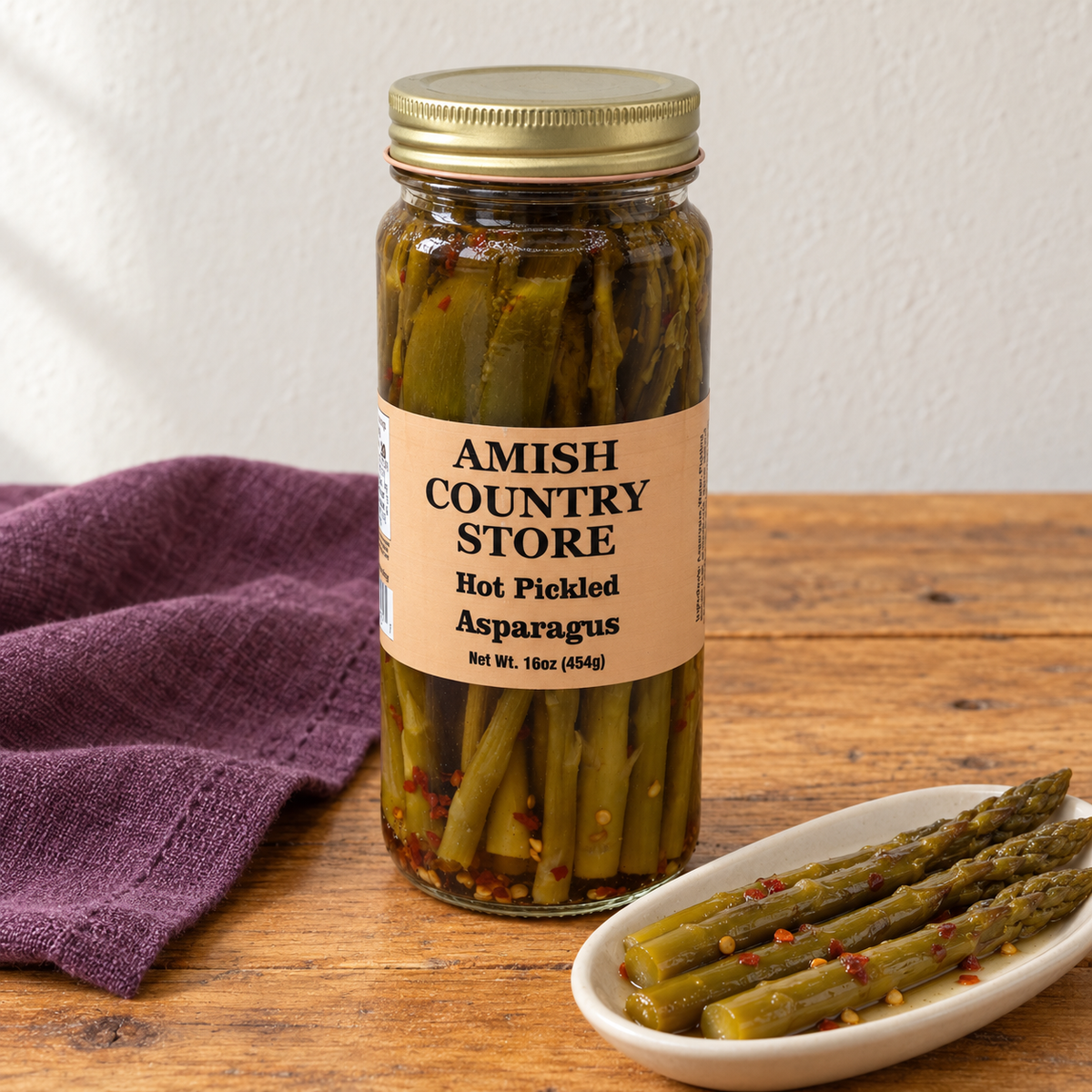 Amish Country Store Hot Pickled Asparagus, 16 oz jar beside whole pickled asparagus spears.