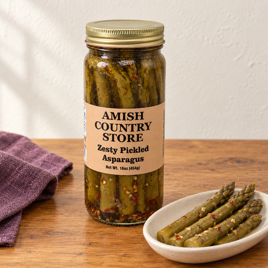 Amish Country Store Zesty Pickled Asparagus, 16 oz jar beside whole pickled asparagus spears.
