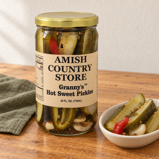 Amish Country Store Granny’s Hot Sweet Pickles,24fl oz jar beside long pickle spears and their brine seasonings.