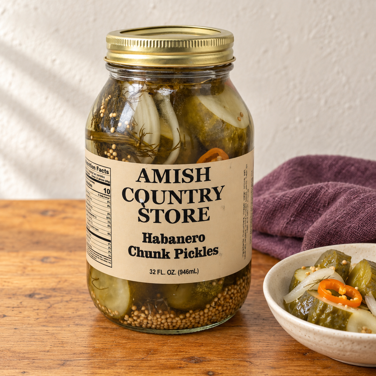 Hot Habanero Pickle Chunks in its original labeled jar with a small serving beside it on a warm wood table.