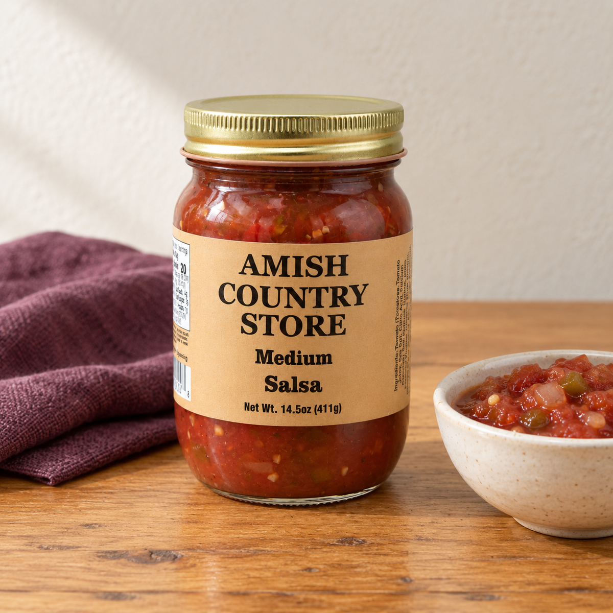 Amish Country Store Medium Salsa,14.5oz jar beside cooked chunky salsa.