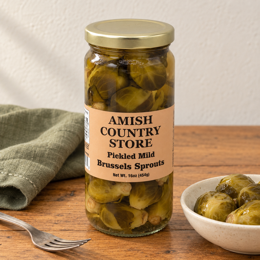 Old-Fashioned Mild Pickled Brussels Sprouts in its original labeled jar with a small serving beside it on a warm wood table.