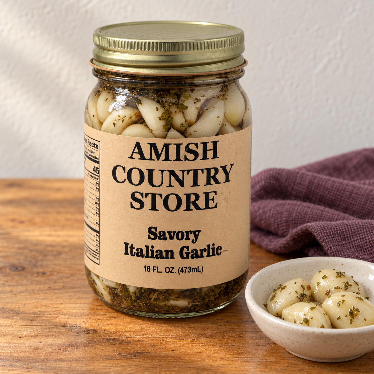 Amish Country Store Savory Italian Garlic, 16 fl oz jar beside herb-flecked pickled garlic cloves.