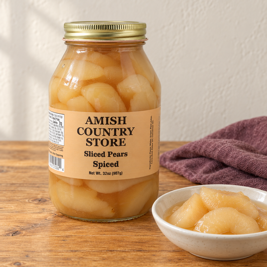 Spiced Sliced Pears in its original labeled jar with a small serving beside it on a warm wood table.