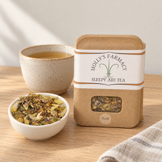 Molly's Farmacy Sleepy Aid Tea, 1/2 oz, beside loose tea and a cup. Styled scene based on the genuine product photo.