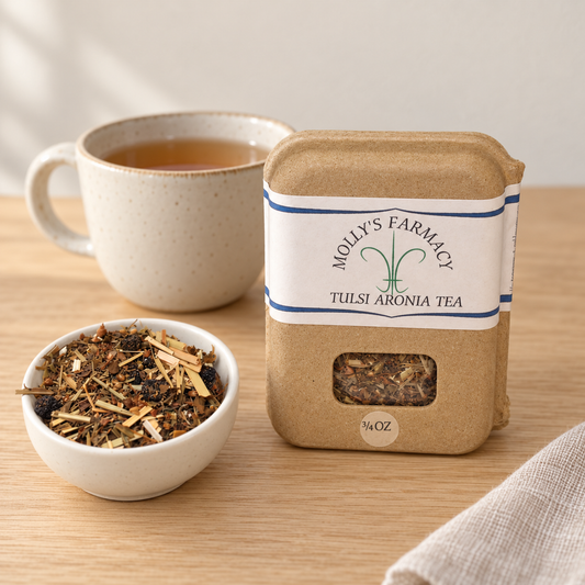 Molly's Farmacy Tulsi Aronia Tea, 3/4 oz, beside loose tea and a cup. Styled scene based on the genuine product photo.