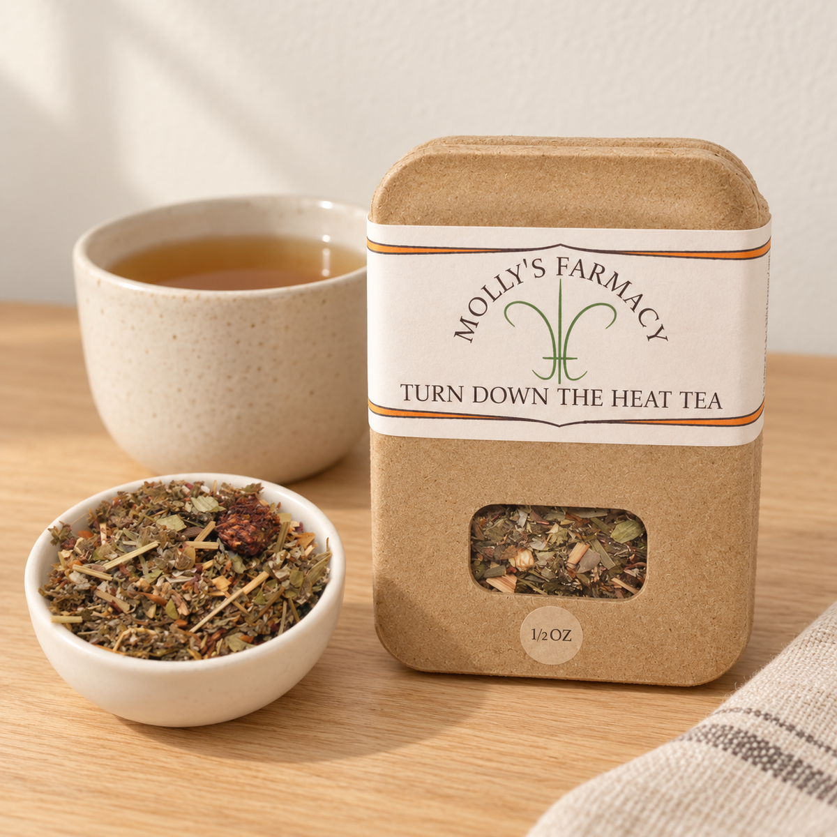 Molly's Farmacy Turn Down The Heat Tea, 1/2 oz, beside loose tea and a cup. Styled scene based on the genuine product photo.