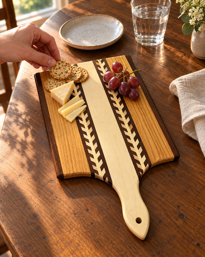 Wheat-pattern paddle board holding a small cheese-and-cracker snack while a hand reaches for a cracker; one board per purchase.