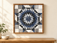 S1198 — wooden barn quilt wall art, square navy, charcoal, pale blue and white layered starburst, shown on an indoor wall in a styled home display