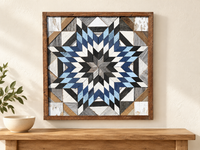 S1199 — wooden barn quilt wall art, square navy, light blue, charcoal and white layered starburst, shown on an indoor wall in a styled home display