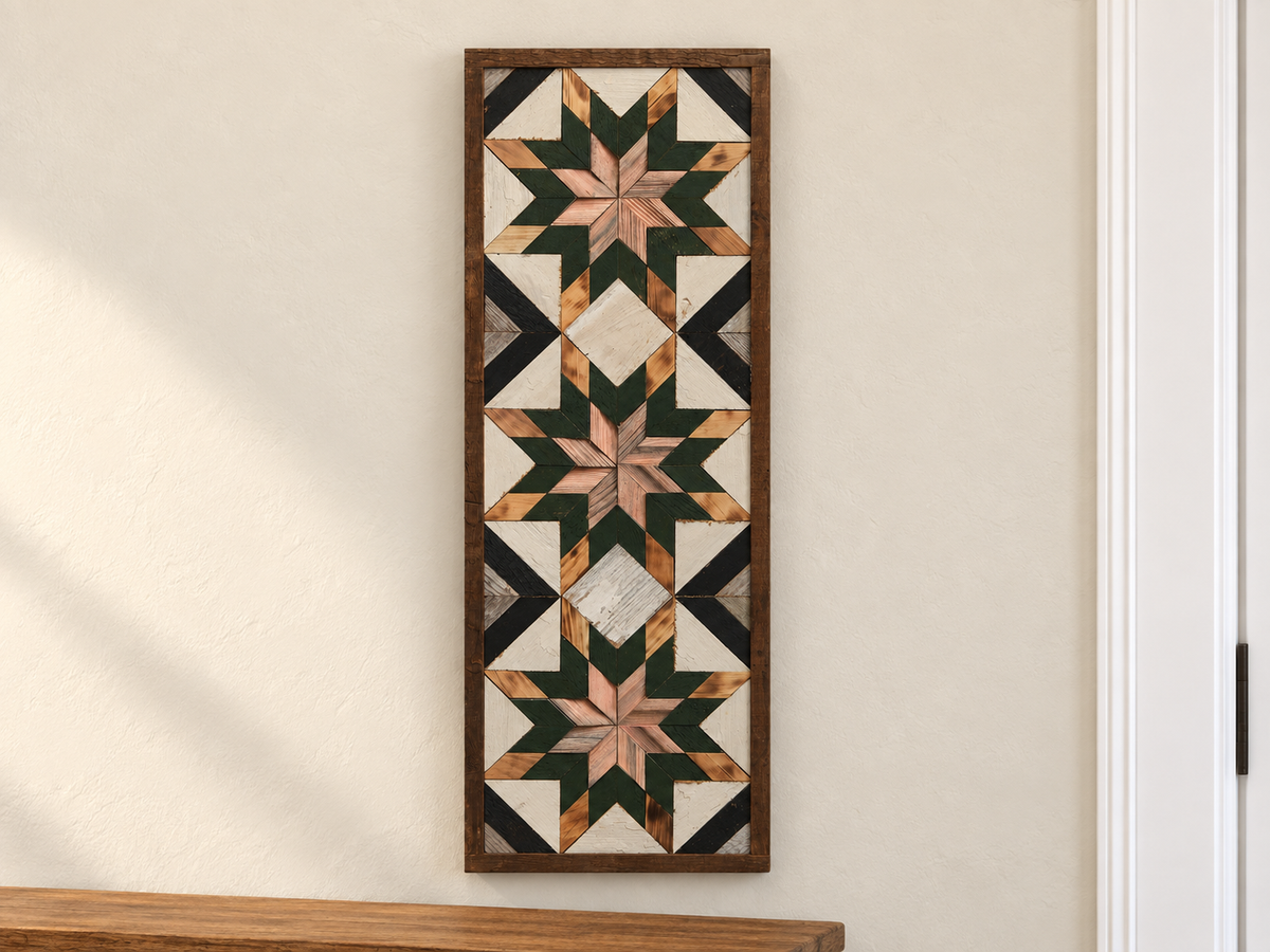 S1218 — tall wooden barn quilt banner wall art, three muted rose wood center stars, forest green middle points, natural tips, white field and black diagonals, displayed on an indoor wall in a styled home