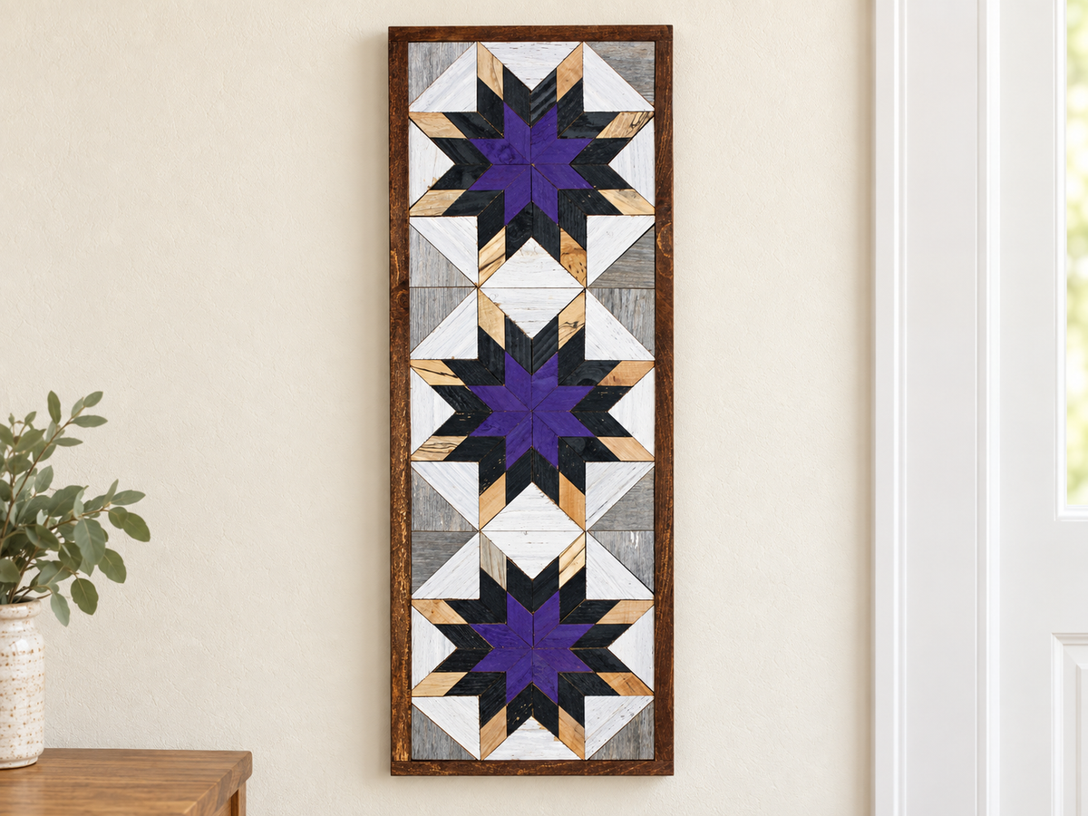 S597 — tall wooden barn quilt banner wall art, three stacked starbursts with purple centers, black middles and natural wood tips, displayed on an indoor wall in a styled home