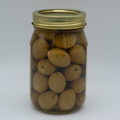 Jar of pickled olives with a gold lid on a white background