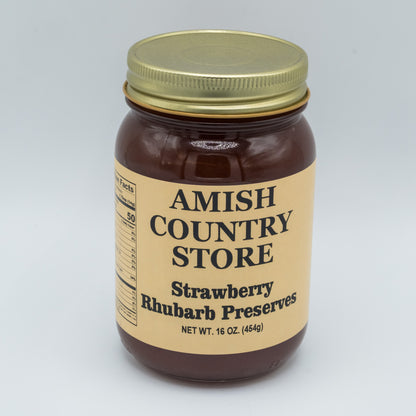 Jar of Amish Country Store Strawberry Rhubarb Preserves with a gold lid on a light gray background