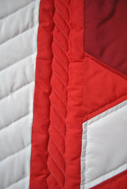fire engine red border with wrapped ribbon quilt design stitched in