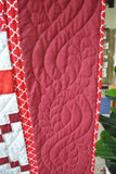 Solid red border with leaf and wave pattern hand stitched into the fabric