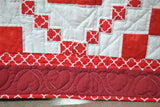 Bottom border of the quilt with heart design and red and white fabric as second border